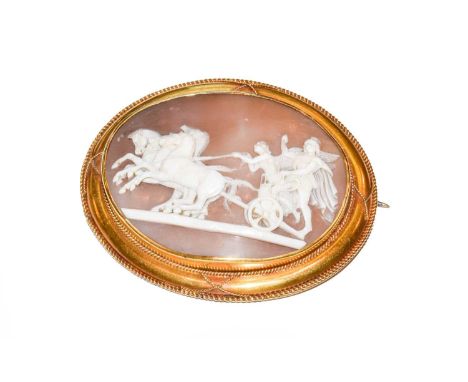 A cameo brooch, the scene depicting figures in a horsedrawn carriage, within a yellow rope twist border , measures 6.4cm by 5