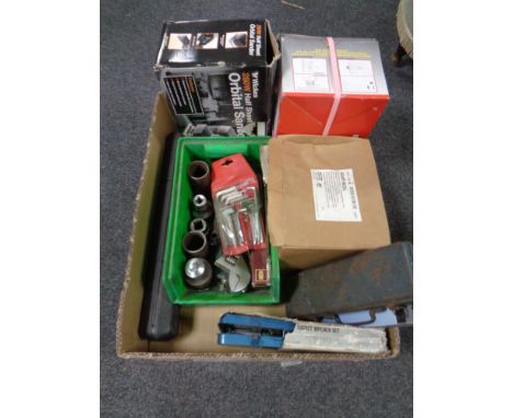A box containing halogen lights, socket sets, orbital sander, alan keys etc