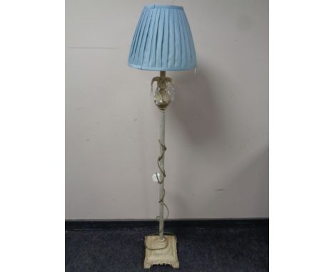 A contemporary metal standard lamp with glass drops and shade