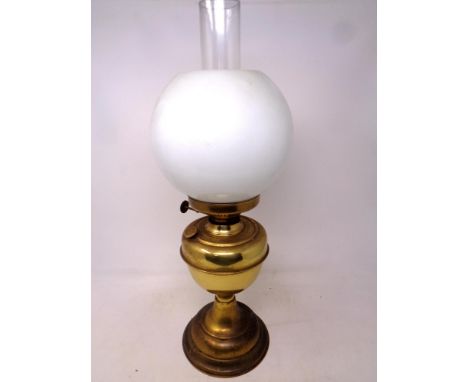 A brass oil lamp with opaque glass shade 