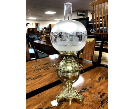 A fine Victorian brass oil lamp, with embossed foliage decoration to the brass reservoir casing above an ornate three-way sup