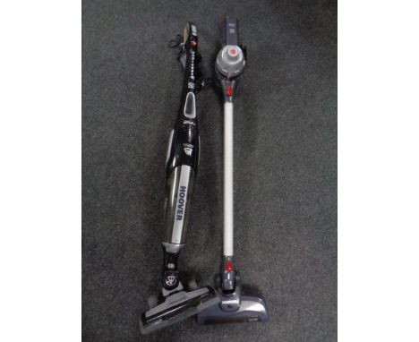 A Hoover cyclone hand held cordless vacuum together with a further Hoover, unplugged stick vacuum both with chargers 