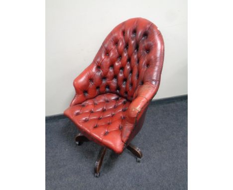 A Chesterfield button leather revolving armchair (red)