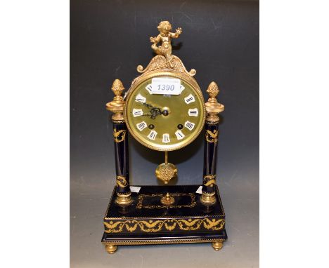An Empire style mantel clock, gilt metal cased dial with putti terminal supported on two gilded blue ceramic columns and pede