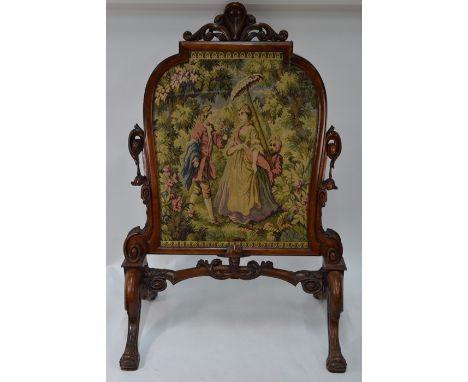 A Victorian walnut framed fire screen in the rococo style, with glazed needlepoint panel, on four moulded feet, 82 cm wide x 