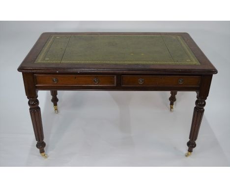 A Victorian mahogany two drawer writing table, the top with inset gilt tooled green leather, raised on turned reeded legs to 