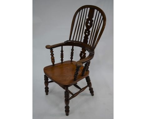 An old elm seated Windsor armchair, with hoop stick back raised on turned legs