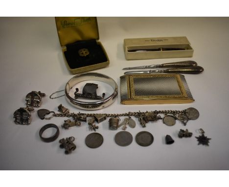 A collection of silver and white metal jewellery items including a curb bracelet with charms attached, a half-hinged oval ban