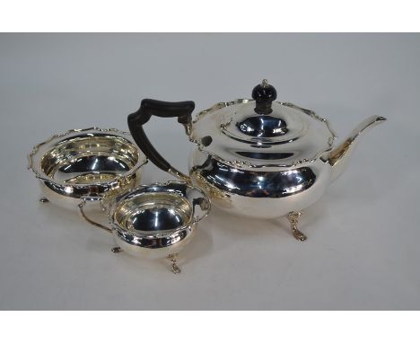 An Edwardian silver three-piece tea service of compressed bun form with shaped rims and hoof feet, Atkin Brothers, Sheffield 