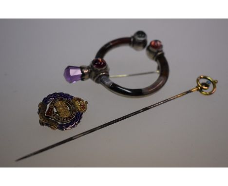 A Scottish cloak brooch, the silver set open brooch set overall with bands of agate, facetted amethyst terminal and three cab