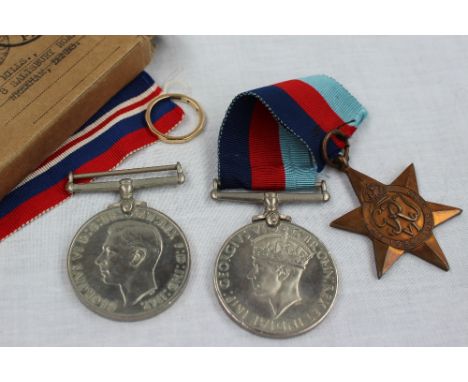 A 9ct yellow gold wedding band, approximately 2 grams together with three World War II medals The British War medal, The Defe