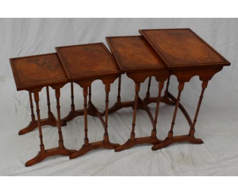 A 20th century walnut quartetto nest of tables the rectangular top on ring turned legs and splayed feet