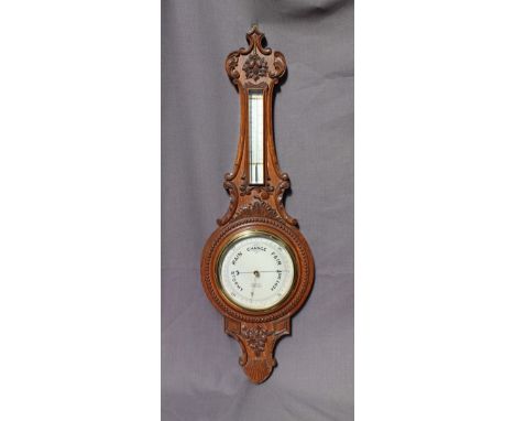 A carved oak aneroid barometer, with a mercury thermometer, the silvered dial inscribed R Bailey, 14 Bennetts Hill, Birmingha