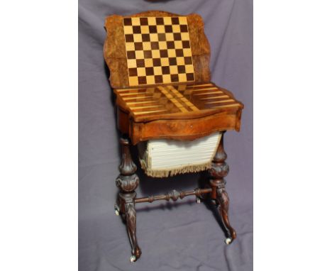 A Victorian burr walnut games / work table, the hinged shaped moulded top enclosing a chequer board, cribbage and bagatelle b