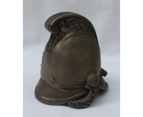 A white metal inkwell in the form of a fireman's helmet, the crest with embossed dragons, 9.5cm high 