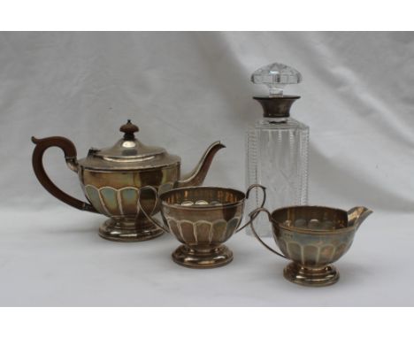 A George V silver three piece tea service, Birmingham, 1930, approximately 950 grams together with a silver topped and cut gl