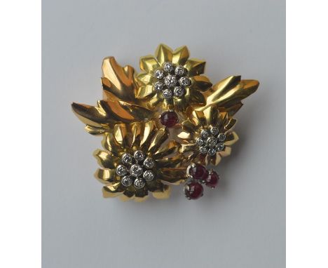 GHISO: A stylish ruby and diamond brooch in the form of a flower in three colour gold with claw mounts. Approx. 13 grams. Est
