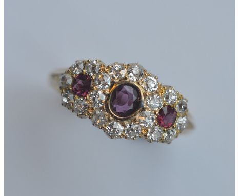 A ruby and diamond triple cluster ring in 18 carat gold. Approx. 5 grams. Est. £1200 - £1500.