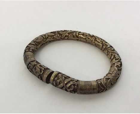 CHINESE: A good quality silver cast torque bangle decorated with figures and leaves. Approx. 106 grams. Est. £50 - £80.