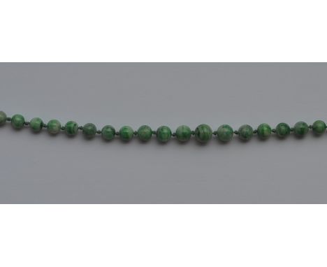 A long graduated string of tapering jade beads and gold ring clasp. Approx. 47 grams. Est. £250 - £350.