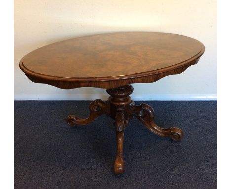A good Victorian walnut pillar table, the base attractively decorated with flowers and scrolls. Est. £200 - £300.