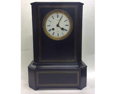 A large French ebony mantle clock with white enamelled dial and blue numerals. Approx. 35 cms high. Est. £50 - £80.