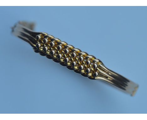 An unusual 15 carat gold keeper bangle with reeded band and concealed clasp. Approx. 16 grams. Est. £800 - £1200.