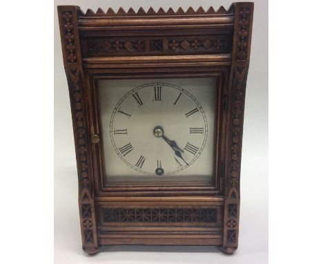 An Edwardian mantle clock with silvered dial in walnut case. Approx. 25 cms high. Est. £50 - £80.