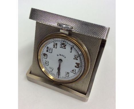 A good quality silver eight day travelling clock with engine turned decoration. Approx. 177 grams. Est. £150 - £200.