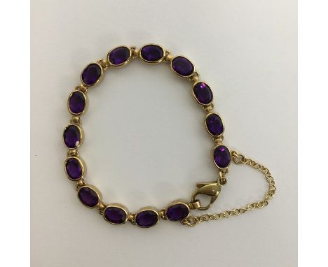 A heavy amethyst and gold bracelet with ring clasp and safety chain. Approx. 16.5 grams. Est. £350 - £400.