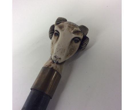 An unusual bone walking stick mount in the form of a ram together with one of a greyhound. Est. £40 - £60.