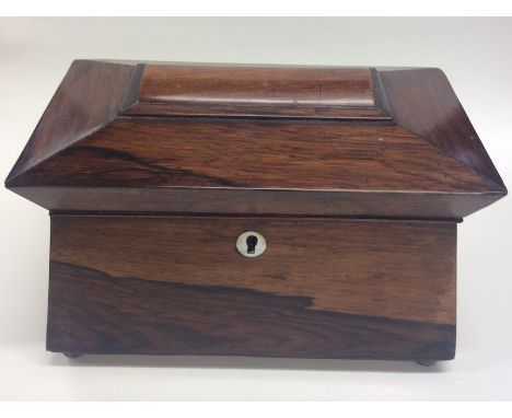 A rectangular rosewood tea caddy on ball feet with fitted interior. Est. £50 - £80.