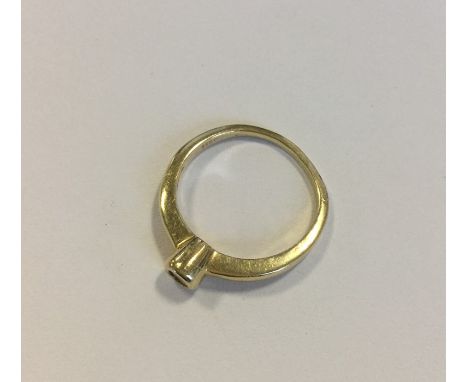 A diamond single stone ring in 14 carat gold rubover mount. Approx. 2.1 grams. Est. £40 - £60.