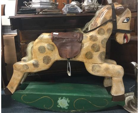 A wooden painted rocking horse with leather seat. Est. £30 - £40.