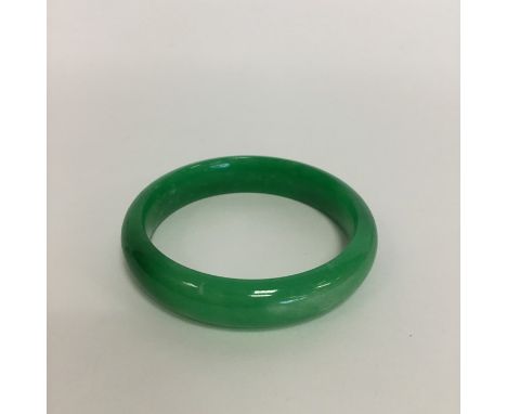A good green jade slave bangle. Approx. 50 grams. Est. £300 - £400.