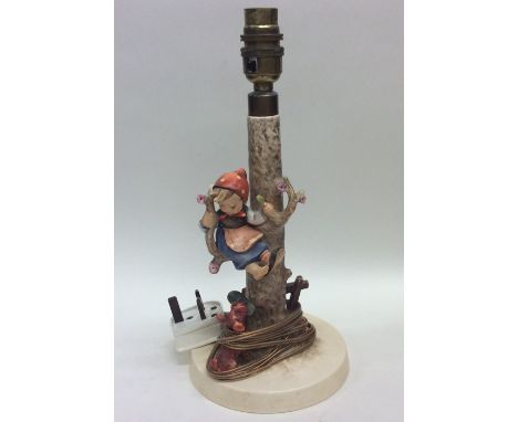 A Goebel lamp decorated with a seated girl sitting in a tree. Est. £25 - £35.
