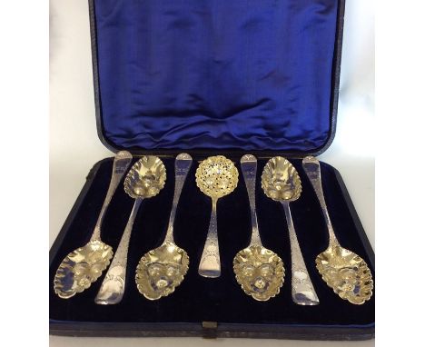 An attractive boxed set of six large silver berry spoons together with matching ladle heavily embossed with fruit and leaves.