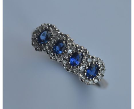 An attractive 18 carat sapphire four cluster ring. Approx. 4 grams. Est. £150 - £250.