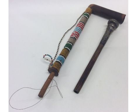 An unusual Continental bead work pipe decorated with bright colours together with one other. Est. £20 - £30.