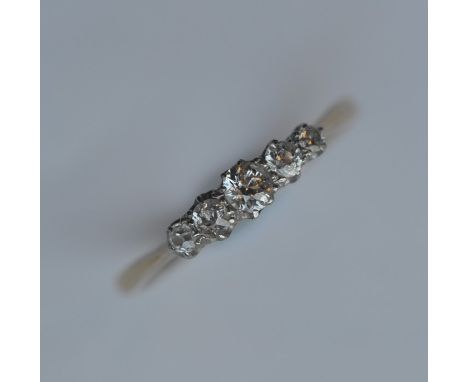 An 18 carat diamond three stone half hoop ring in two colour claw mount. Approx. 3 grams. Est. £200 - £300.