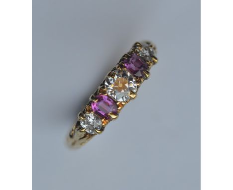 A ruby and diamond five stone half hoop ring in carved mount set in 18 carat gold. Est. £400 - £500.