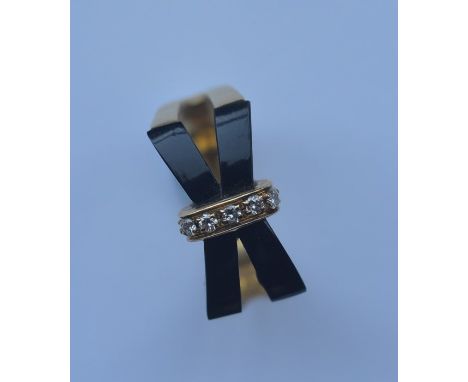 A stylish 18 carat diamond and onyx ring of crossover design. Approx. 6 grams. Est. £80 - £120.