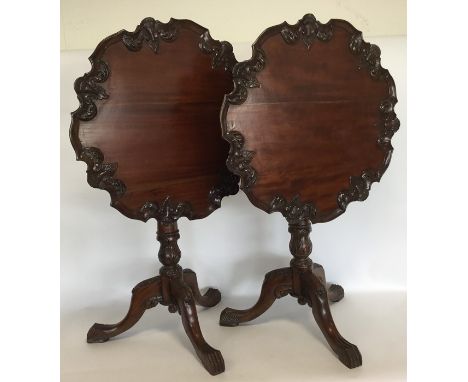 A pair of reproduction mahogany pillar tables decorated with scrolls and flowers on leaf cap feet. Est. £150 - £200.