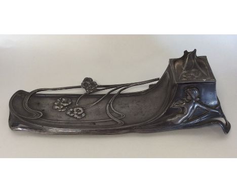 A stylish WMF inkwell in the form of a lady in seated position. APprox. 29 cms long. Approx. £20 - £30.