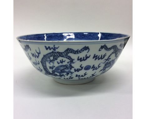 A Chinese blue and white bowl decorated with dragons. Seal mark to base. Approx. 20 cms in diameter. Est. £50 - £80.