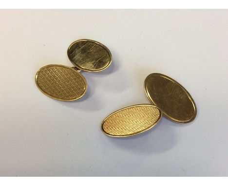 A pair of 9 carat engine turned cufflinks. Approx. 7 grams. Est. £40 - £60.