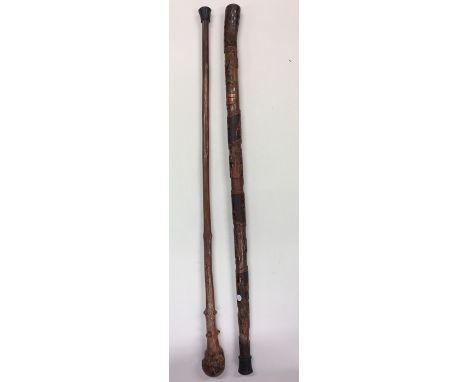 An unusual walking stick with fist ball decoration together with one other. Est. £20 - £30.