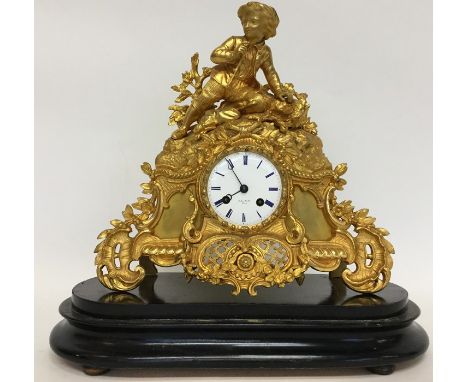 An attractive mantle clock flamboyantly decorated with gilding and figures with white enamelled dial contained within a dome 