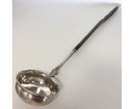 A large Georgian silver toddy ladle with twisted whalebone handle. Approx. 44 cms long. Est. £60 - £80.