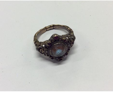 An Antique gem set cluster ring in heavily embossed mount. Approx. 7 grams. Est. £100 - £150.